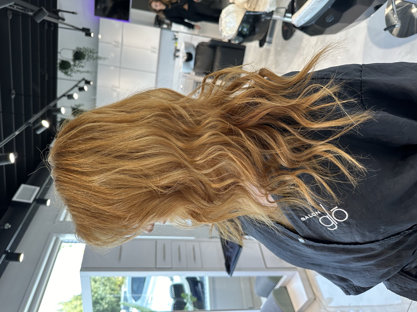 Long copper-blonde curled hair, three-quarter view