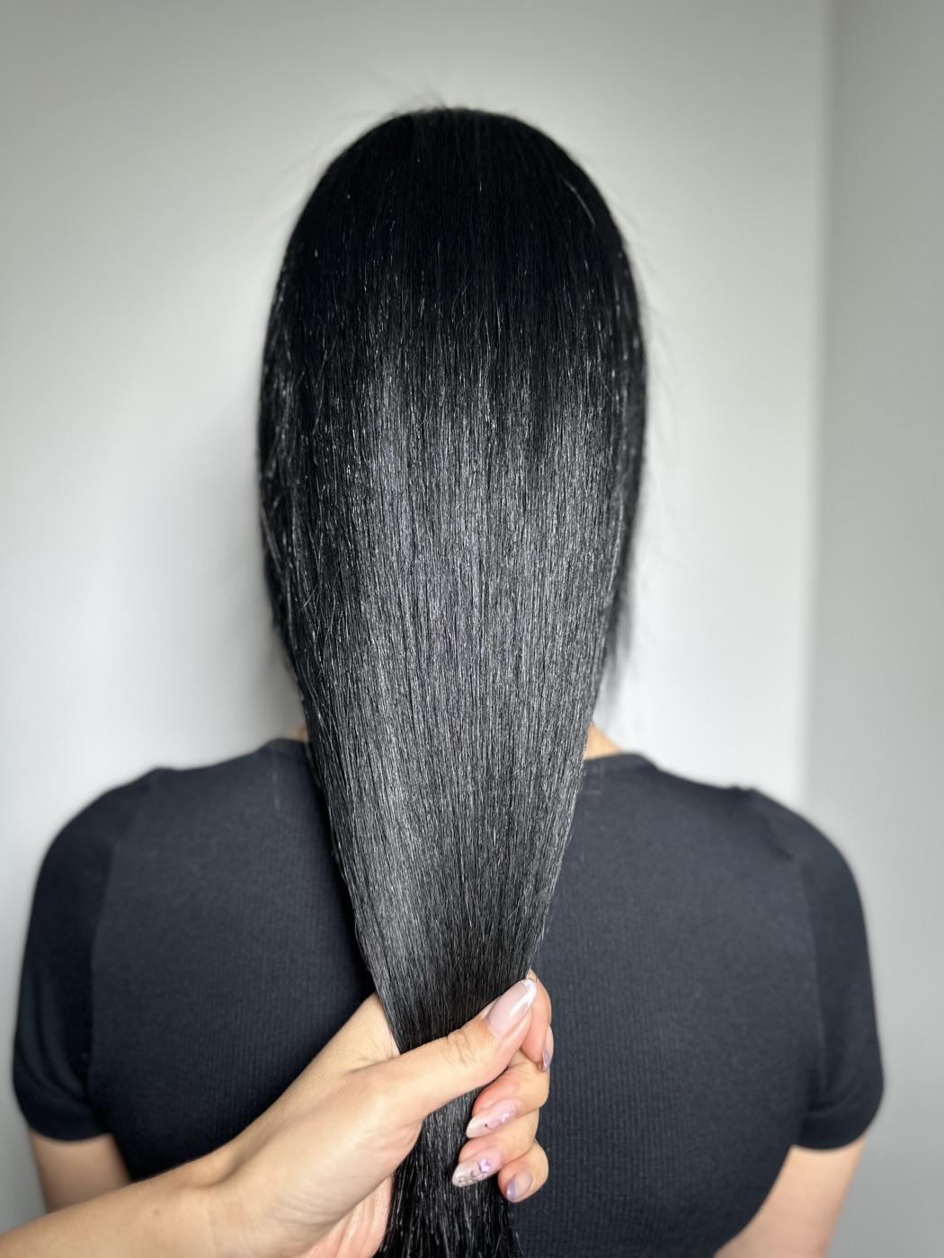 Long sleek black hair, held forward